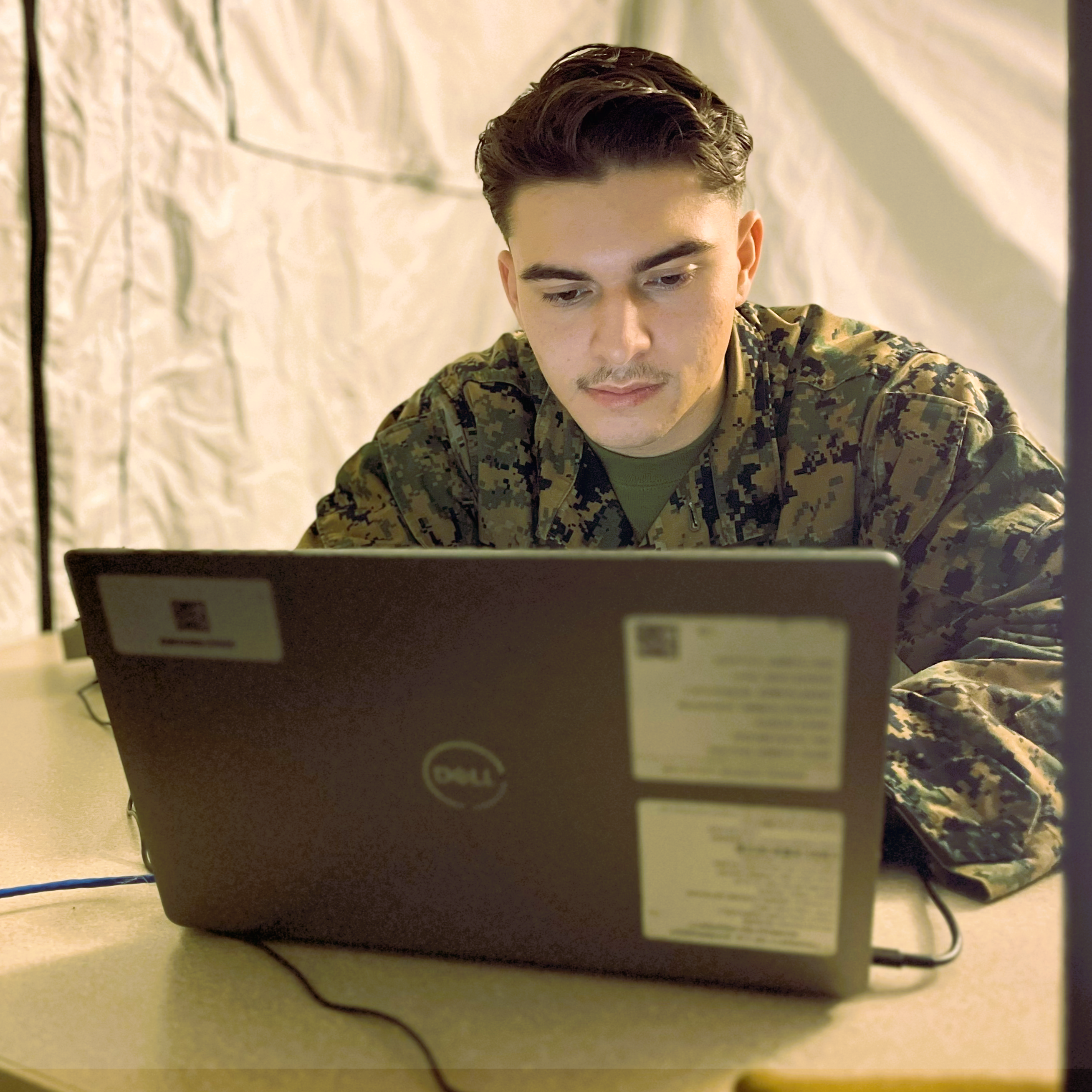 Jacob Tapfar - U.S. Marine Corps Reservist and TapfarTech Founder working on laptop